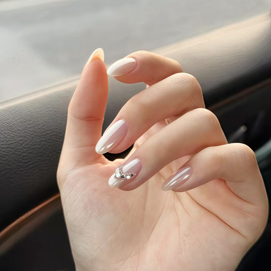 Minimalist handmade press-on nails in pearl finish with crystal details on model hand