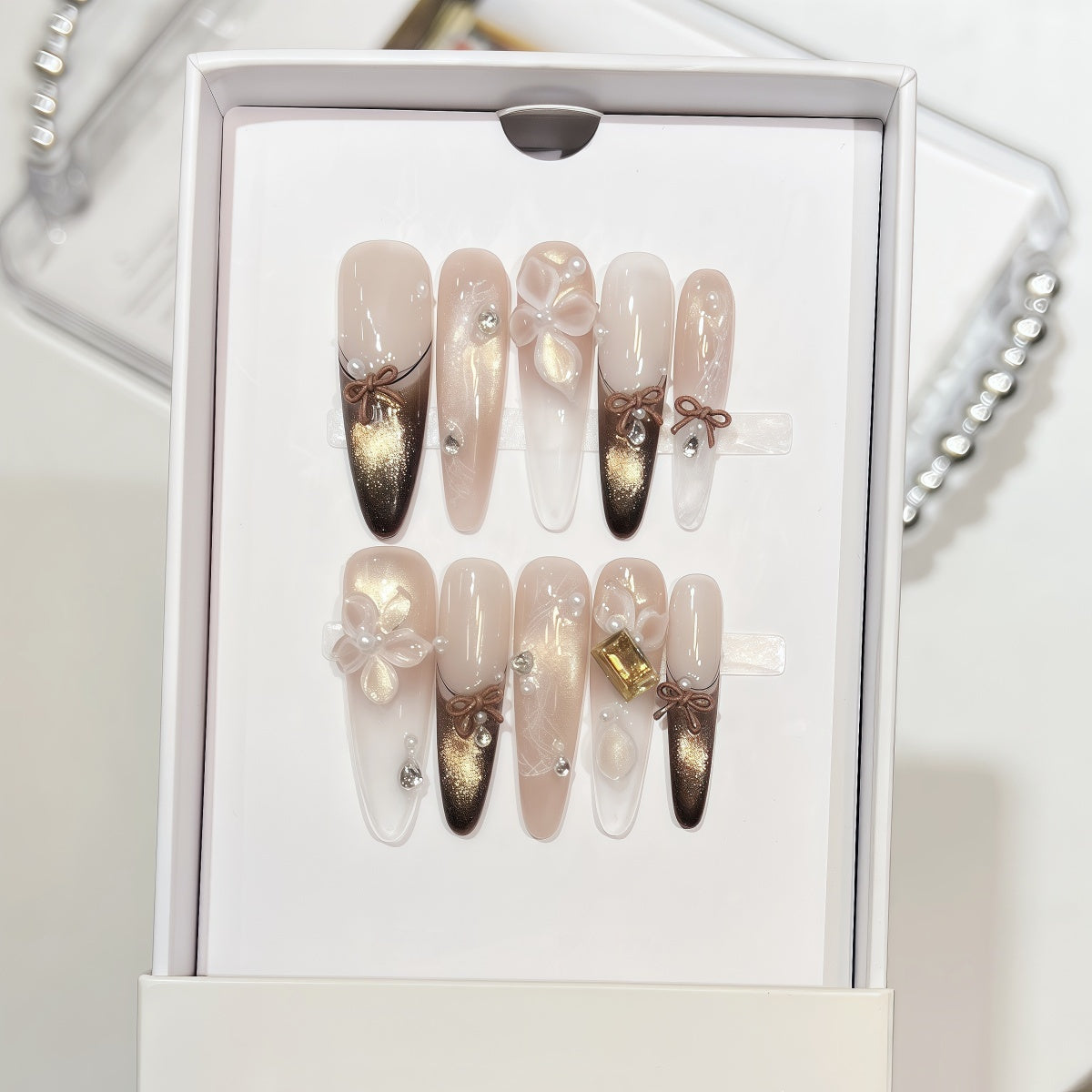 Extra-long nude and gold cat eye french tips handmade press-on nails with 3D bow and floral accents