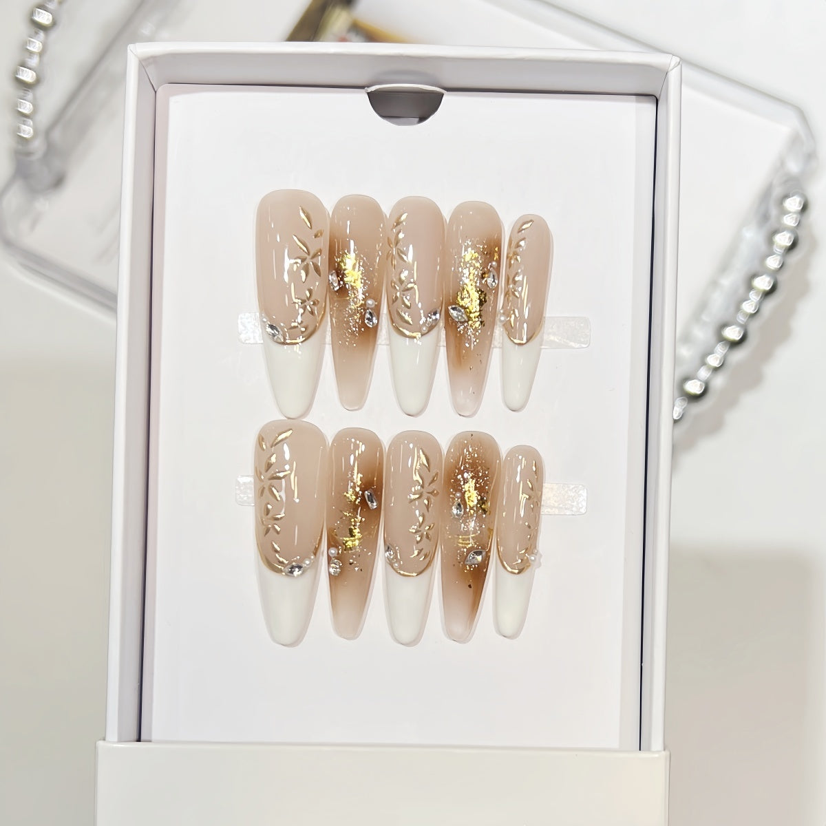 Hand-painted French tip press-on nails with gold foil and rhinestone accents