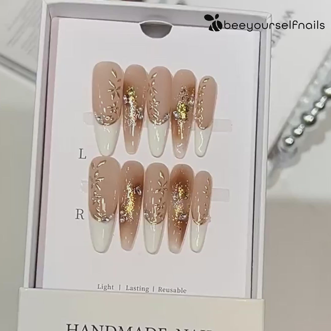 Hand-painted French tip press-on nails with gold foil and rhinestone accents 